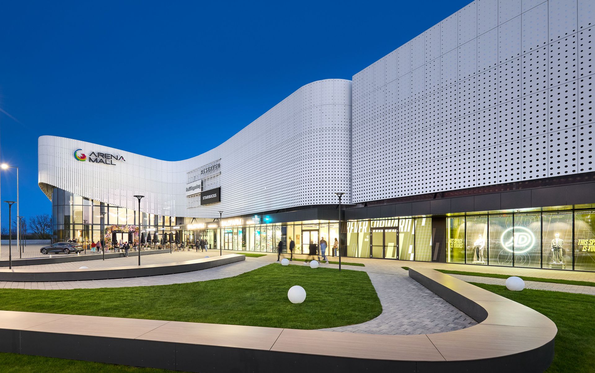 Fațada iluminată seara a Arena Mall Bacău, cel mai mare centru comercial din regiunea Moldovei după extindere