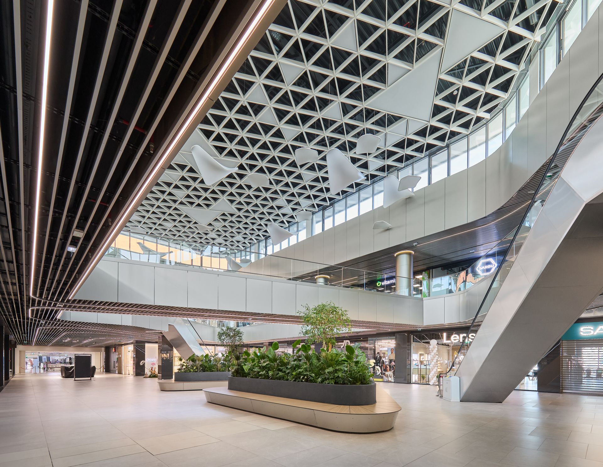 Atrium interior cu plafon din lamele de lemn, scări rulante și jardiniere verzi, Arena Mall Bacău