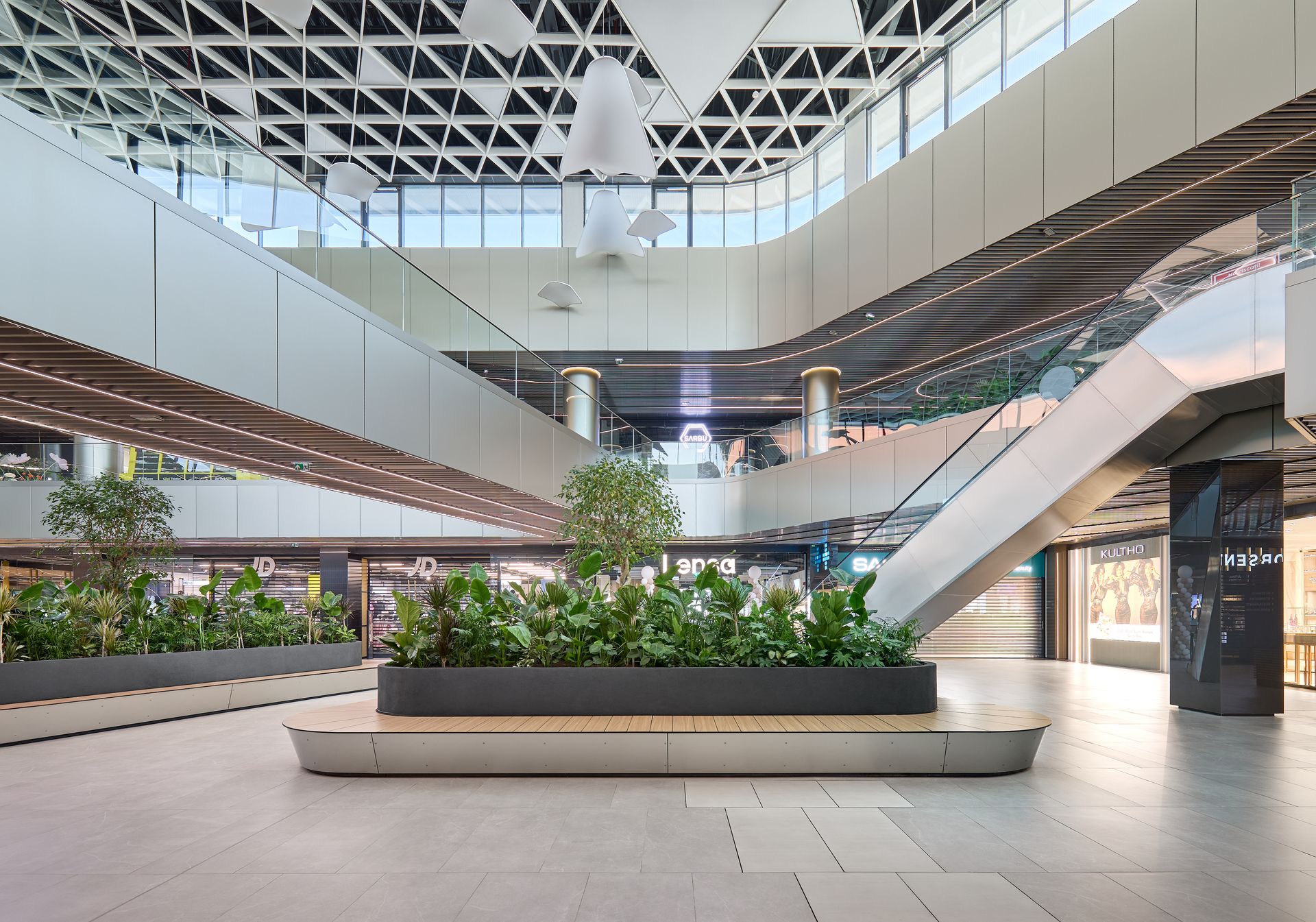 Atrium interior luminos cu plafon sculptural alb și vegetație, Arena Mall Bacău